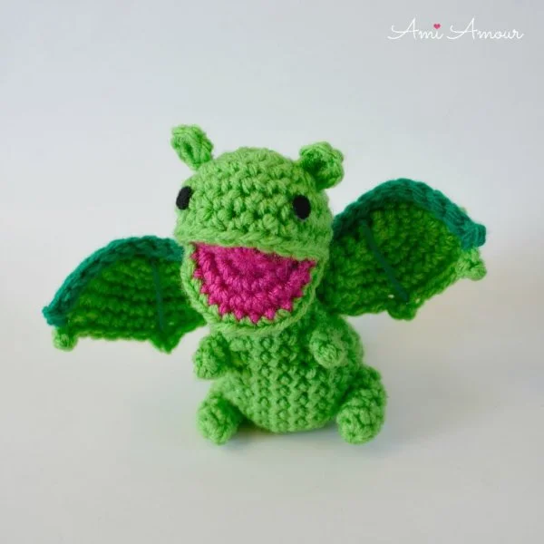 An open-mouthed crochet baby dragon.