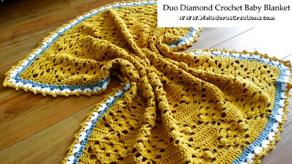 Yellow filet crochet baby blanket with blue and white contrast edging.