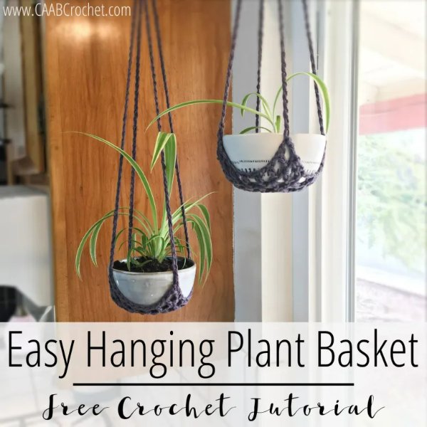 Two potted plants hanging in front of a window in brown crochet plant baskets.