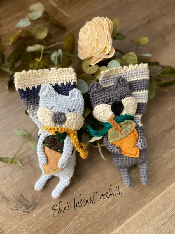 Two rag doll crochet squirrels holding acorns.