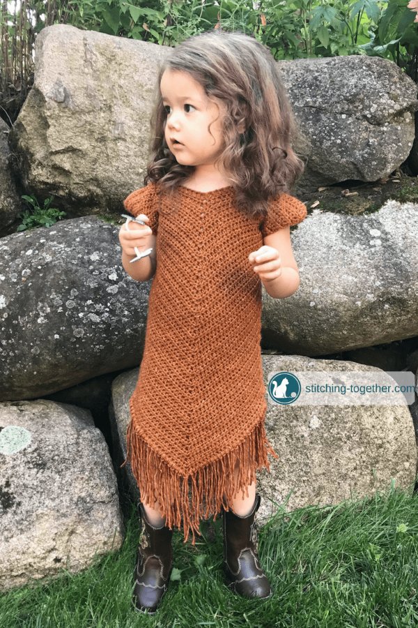 Rust coloured crochet toddler dress with fringing.