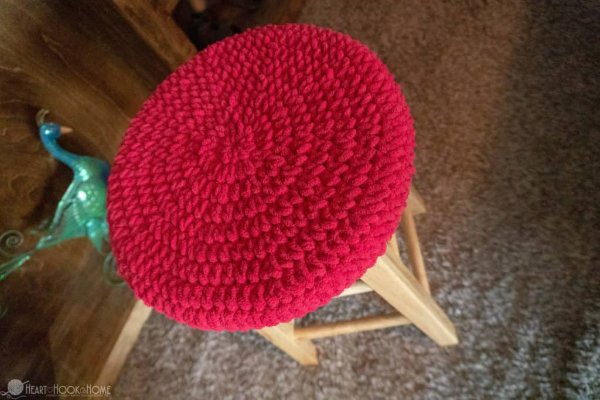 A bright red crochet stool cover.
