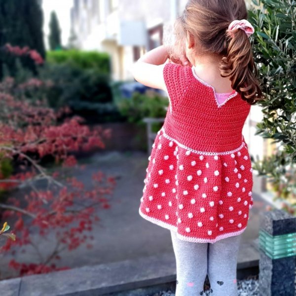 Red crochet toddler dress with dotty skirt.