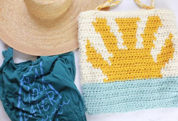 A tapestry crochet beach bag with a sun motif.