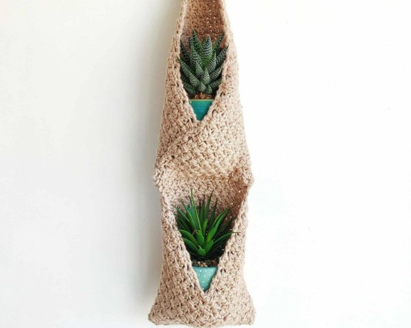 A crocheted double wall hanging basket with small succulents.