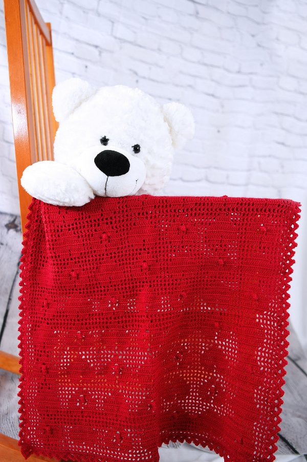Heart design filet crochet blanket and a polar bear toy.