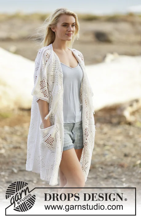 A woman outdoors wearing a white crochet cover-up.