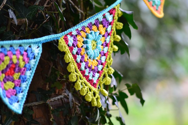 A multicoloured crochet garland with popcorn stitch edging.