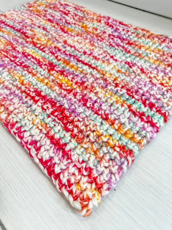 A multicoloured bright crochet bath rug.