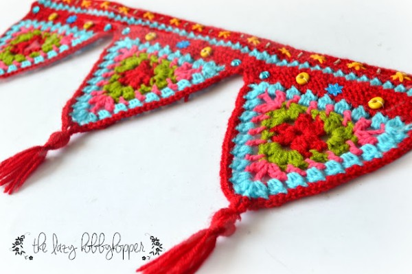 A brightly coloured crochet bunting in red and blue with tassels.