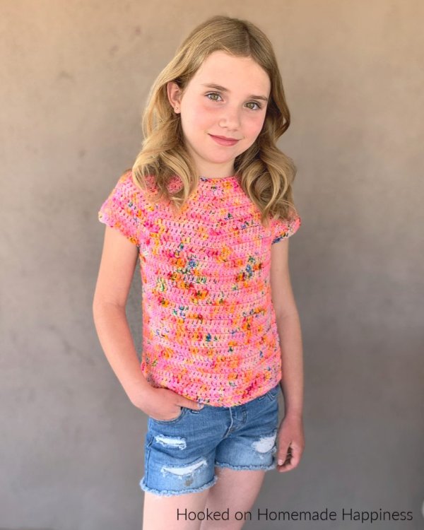 A child wearting a pink crochet t-shirt.