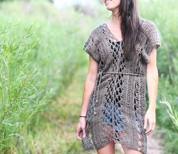 A woman wearing a lacy brown crochet tunic.