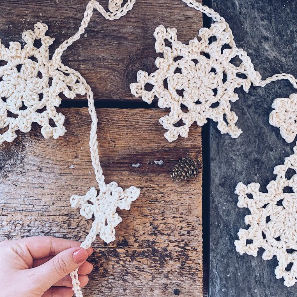A white crochet garland on a timber bnackground.