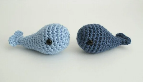 Two tiny blue crochet whales.