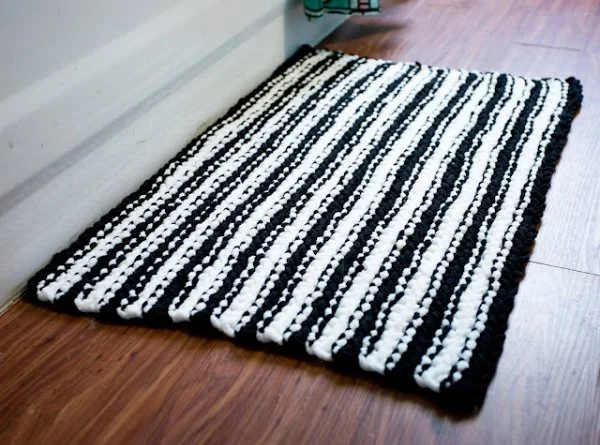 A black and white striped crochet bath mat.