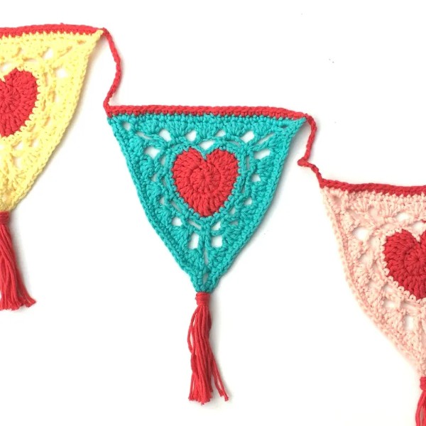 A crochet granny triangle garland with heart motifs.