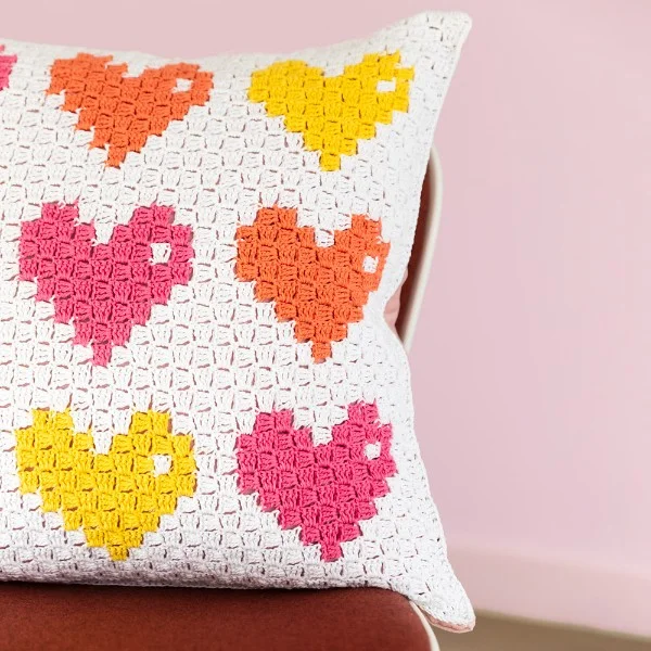 A C2C crochet pillow with hearts.