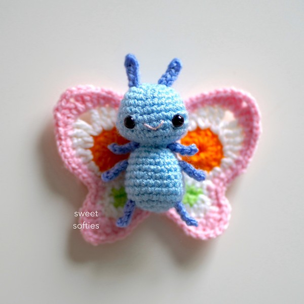 A cute crochet butterfly with a blue body.