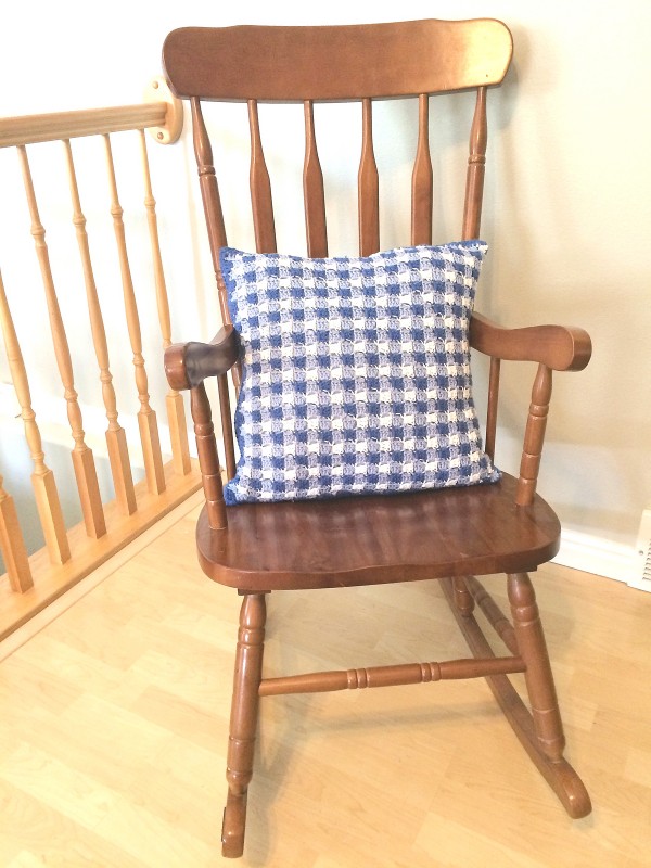 Gingham C2C crochet pillow on a wooden chair.