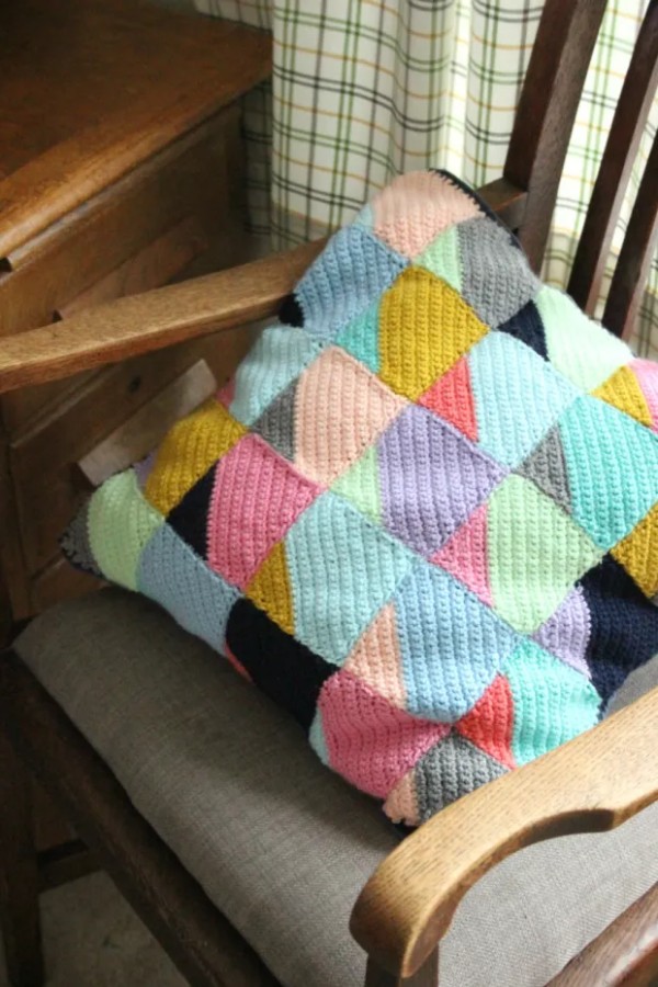 A corner-to-corner crochet cushion with a gemoetirc design.