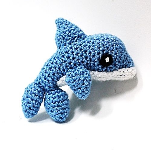 A small blue crochet dolphin amigurumi.