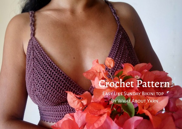 A woman wearing a purple crochet bralette holding a bunch of flowers.