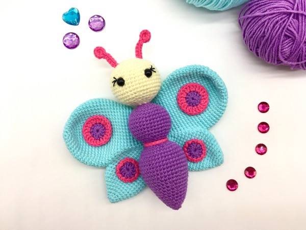 A brightly coloured crochet butterfly softie toy.