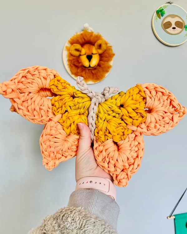 A large crochet butterfly in orange tones.