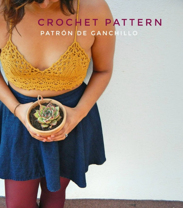 A woman wearing a yellow crochet bralette holding a succulent.