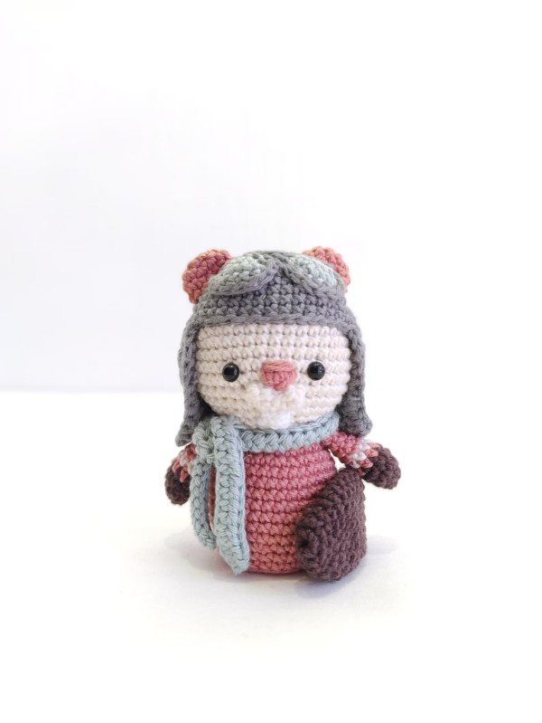 A crochet beaver with a scarf on a white background.