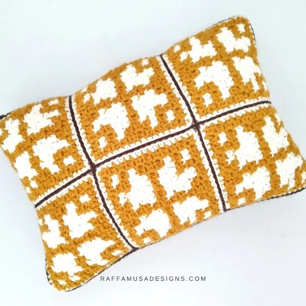 A mini C2C crochet pillow with a geometric design.