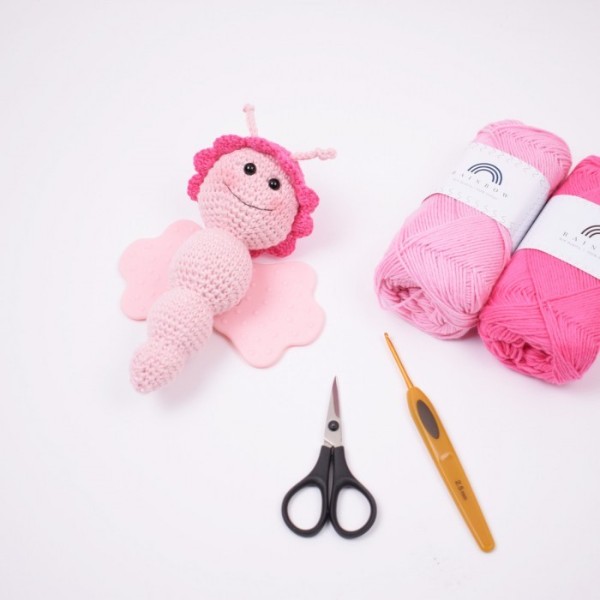 A pink crochet butterfly sensory toy.