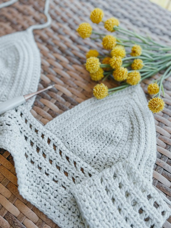 A white crochet bralette and a bunch of yellow flowers.