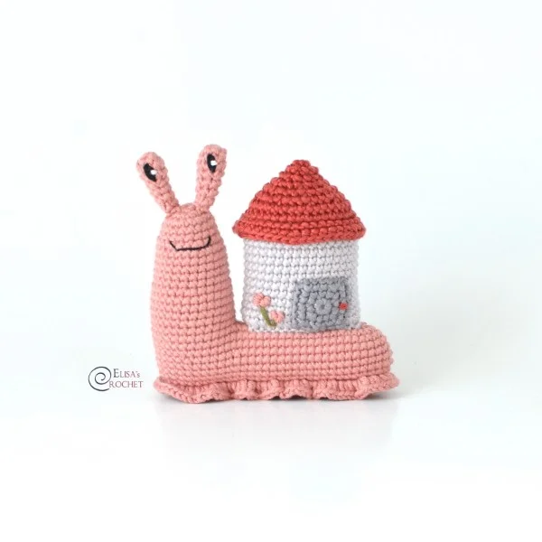 A pink crochet snail with a house shell.