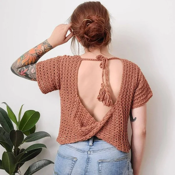 Back-view of a woman wearing an open-backed crochet lace top.