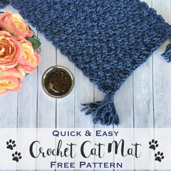 Navy blue crochet cat mat with tassels.