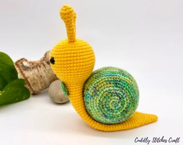A yellow and green crochet snail.