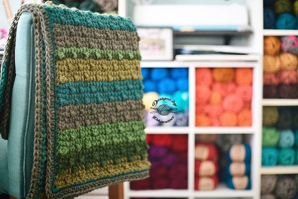 A striped Tunisian crochet blanket featuring the bobble stitch.