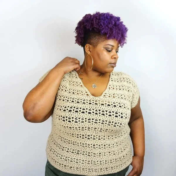 A woman wearing a v-neck crochet lace top.