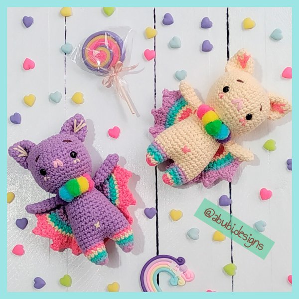 Two colourful crochet bats iwth confetti background.