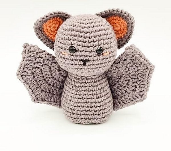 A swwet looking crochet bat in soft tones on a white background.