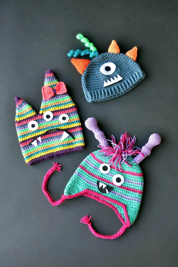 Three crochet monster hats.