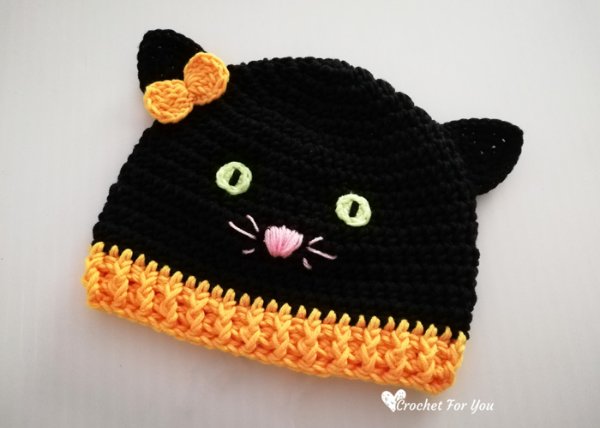 A crochet black cat hat with an orange brim.