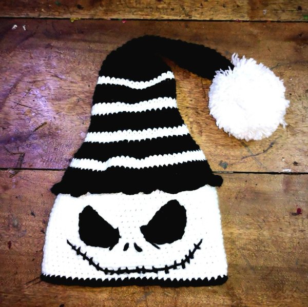 A black and white beanie with a pom-pom and skull face.