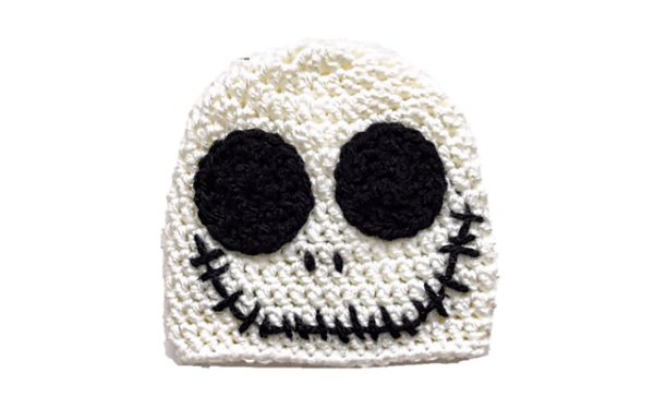 A white crochet skull hat on a white background.