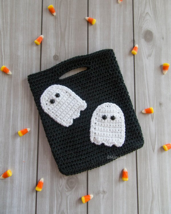 A crochet trick or treat bag with ghost applique.
