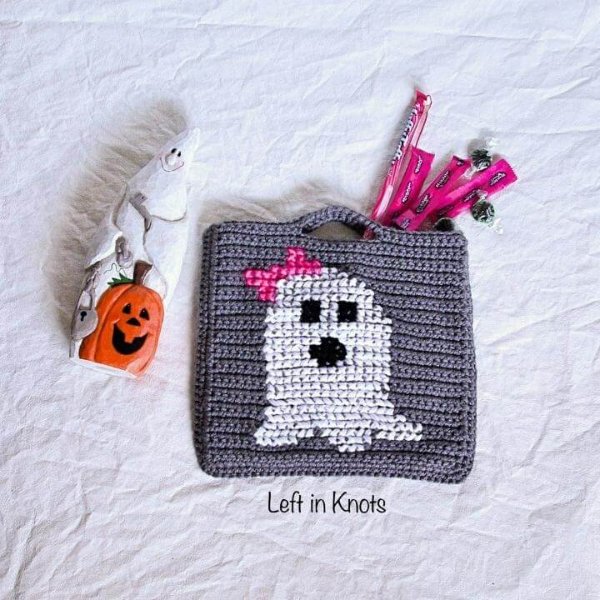 A small crochet halloween treat bag with a ghost motif.