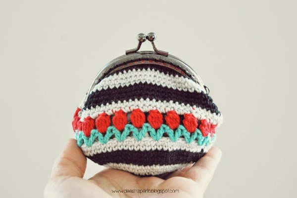 A stripeed crochet coin purse decorated with the tulip stitch.