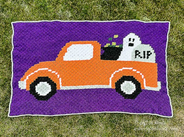 A purple and orange crochet halloween blanket.