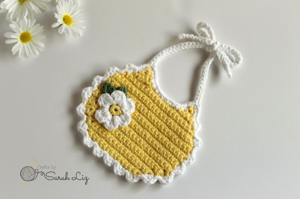 Yellow crochet bib with daisy applique.